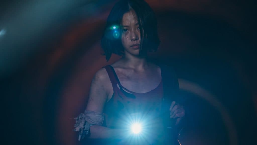 une jeune fille (lee eun-yu) tient une lampe torche dans un tunnel sombre